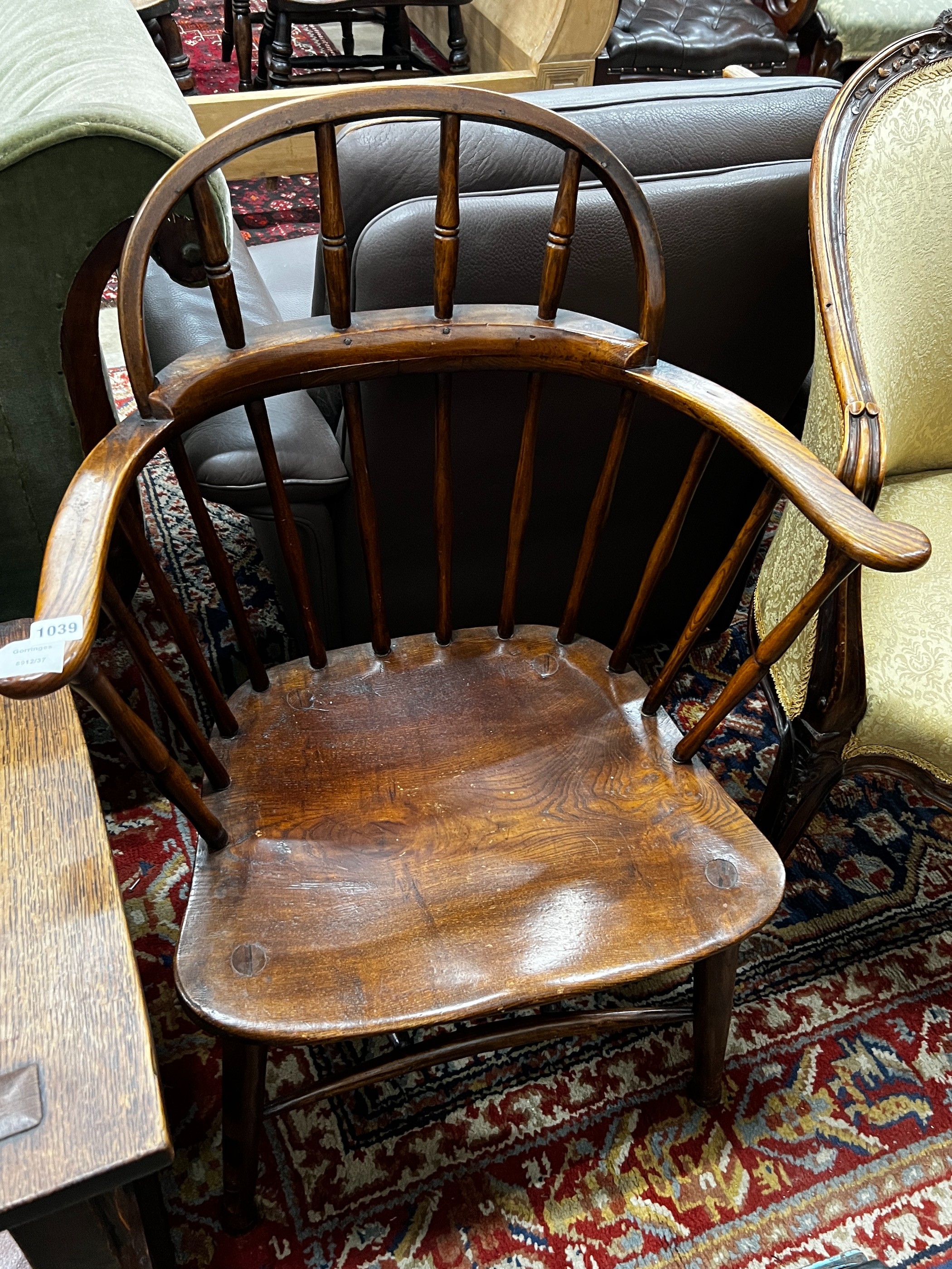 An early 20th century Windsor ash and elm comb back elbow chair, width 66cm, depth 41cm, height 92cm